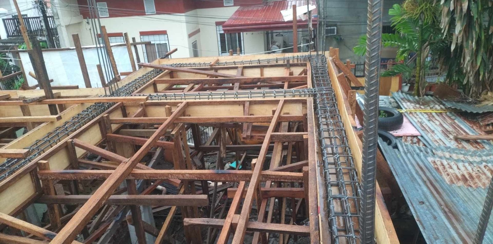 Duplex enhancements for 2-storey residential building in balulang, cagayan de oro city 2 Construction site showing the reinforcement work for a second-floor slab, with wooden formworks and steel rebar cages in place, ready for concrete pouring.