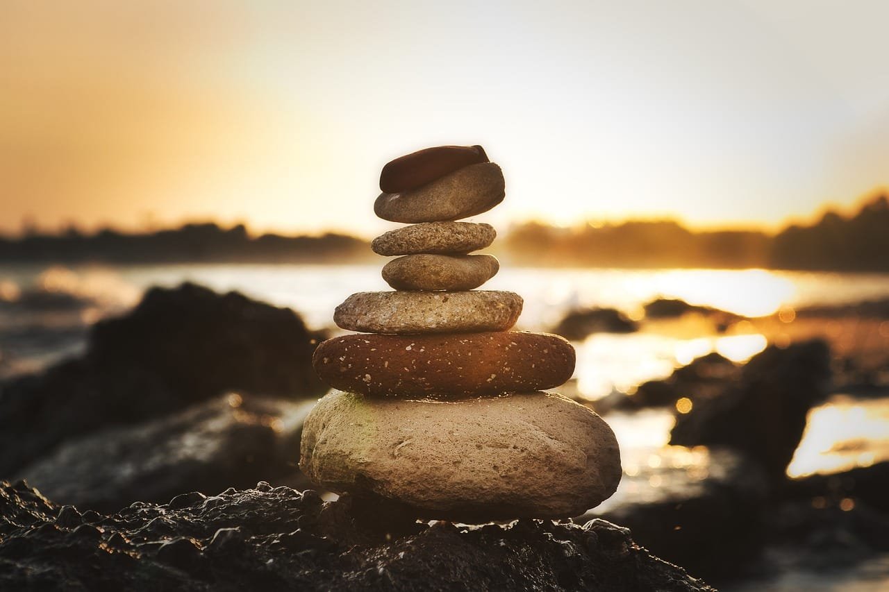 A stack of balanced stones symbolizing perseverance and stability, representing the power of grit and strategy in winning projects.