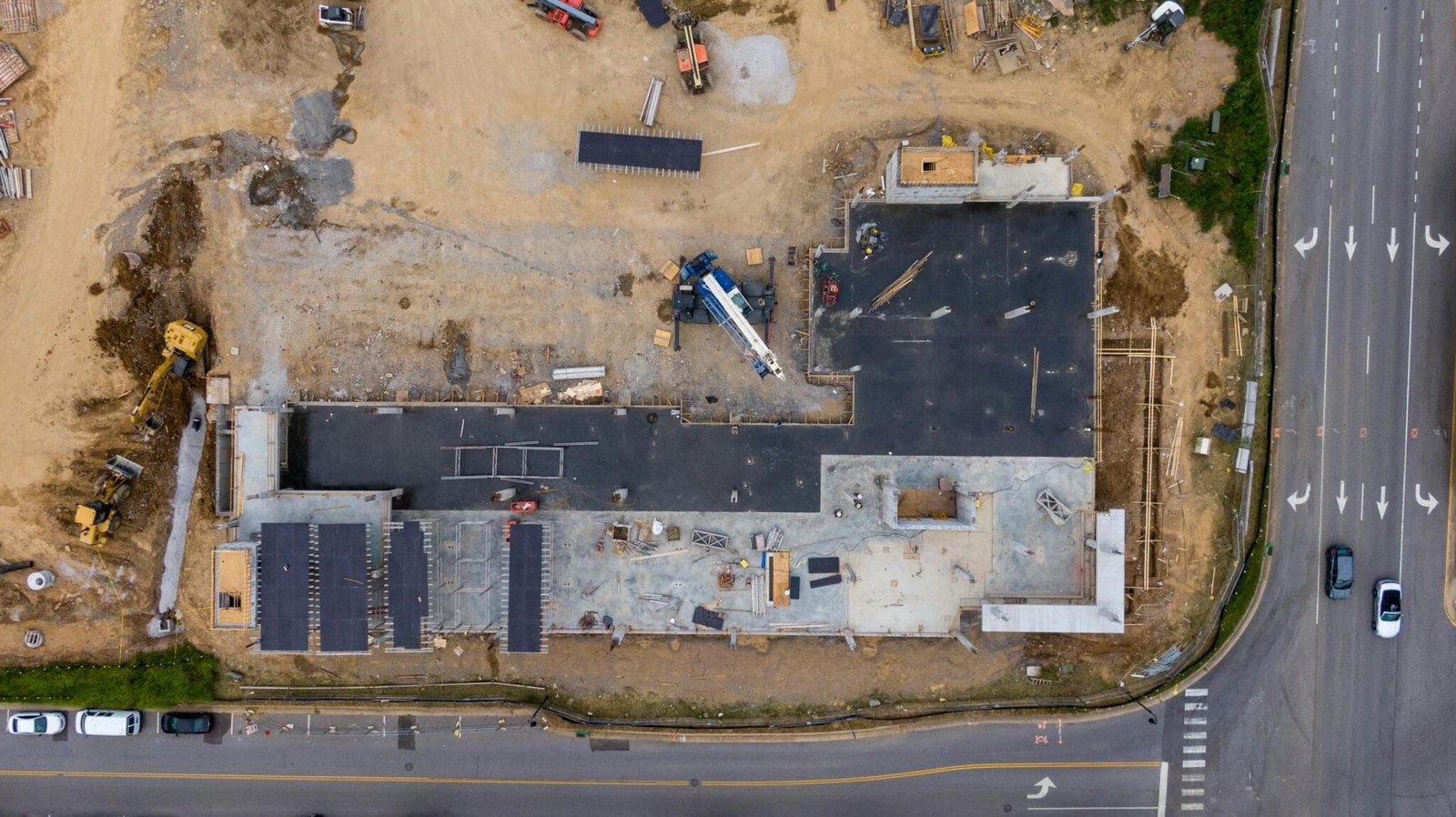Aerial view of an active construction site development with machinery and vehicles.