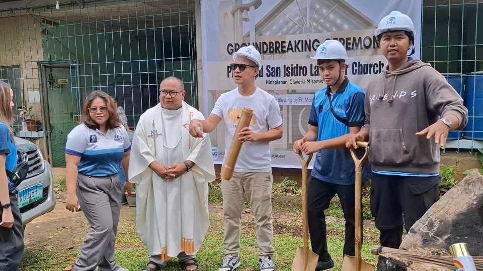 Priest and volunteers during church groundbreaking