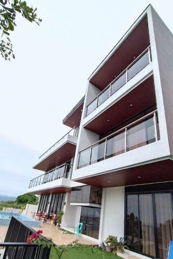 Teakwood hills luxury mansion – cagayan de oro 5 Side elevation of a multi-level modern home by jmg