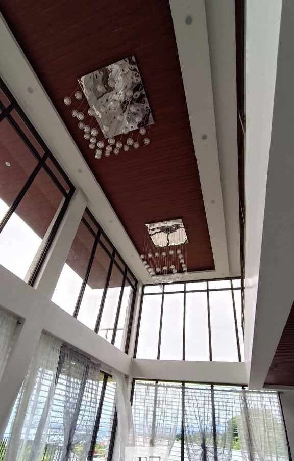 Teakwood hills luxury mansion – cagayan de oro 4 Floor-to-ceiling windows and chandelier in cdo high-ceiling space