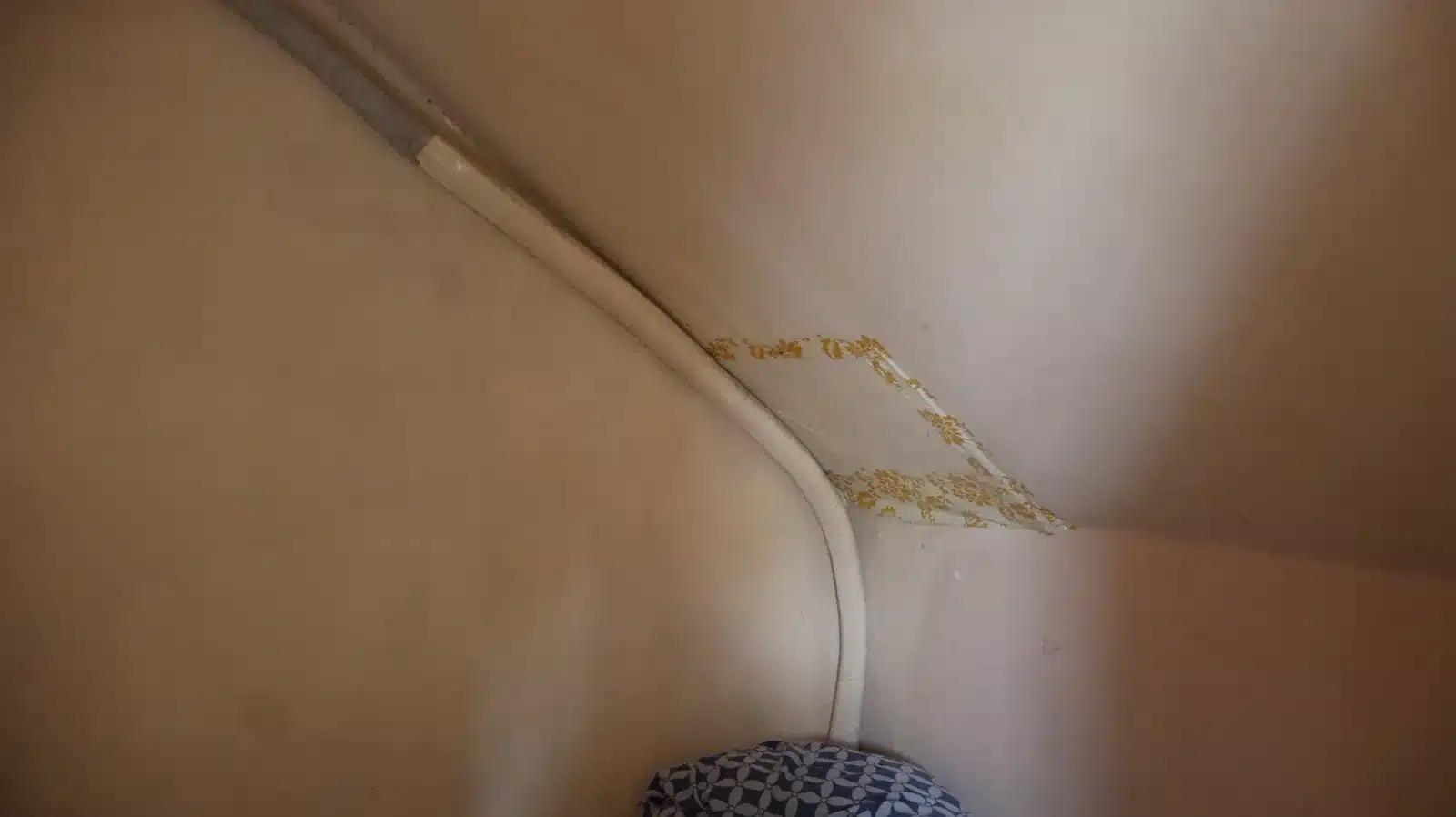 Property condition assessment & indicative value range: camella gran europa, lumbia, cagayan de oro 6 Interior ceiling and wall corner with a patched, water-stained area covered by plastic sheet, camella gran europa house, cagayan de oro