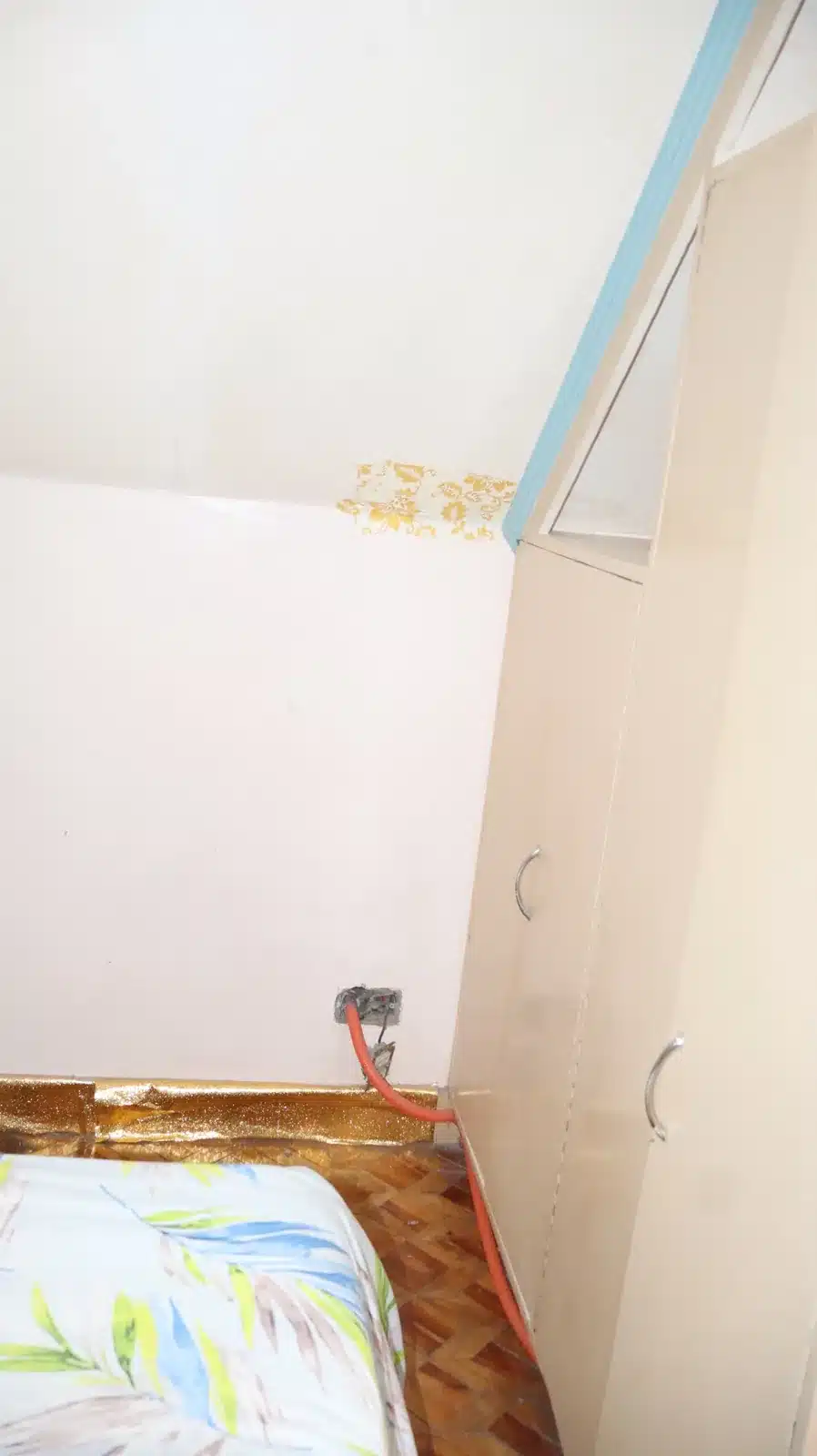 Property condition assessment & indicative value range: camella gran europa, lumbia, cagayan de oro 7 Upper corner of a bedroom wall with a stain near the ceiling and window frame above a parquet floor, camella gran europa house, cagayan de oro