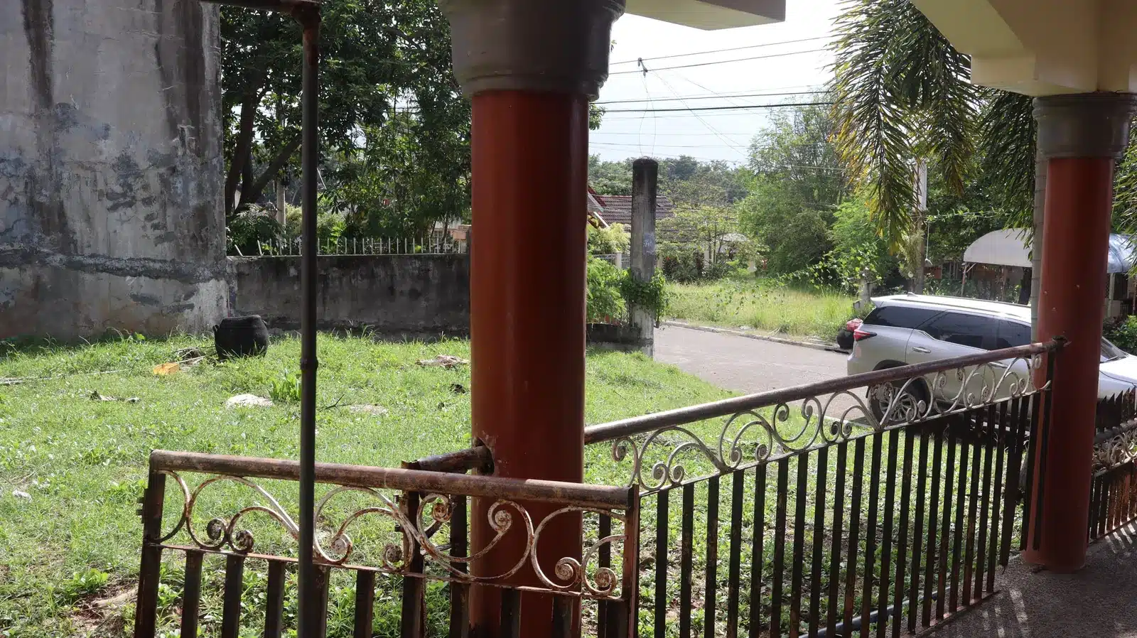 Property condition assessment & indicative value range: camella gran europa, lumbia, cagayan de oro 14 Red porch columns and weathered wrought-iron railing looking toward the street, camella gran europa house, cagayan de oro