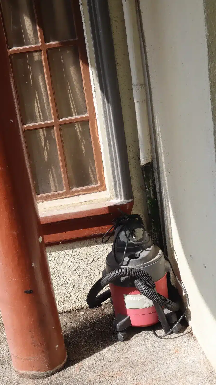 Property condition assessment & indicative value range: camella gran europa, lumbia, cagayan de oro 18 Side wall of a camella gran europa house with a window, a downspout pipe, a red column and a stored wet-and-dry vacuum, cagayan de oro