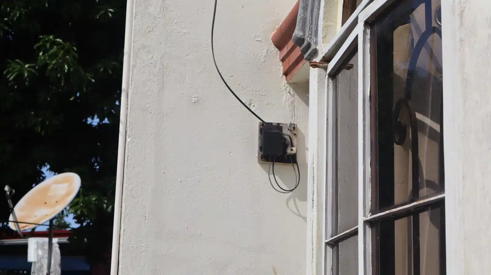 Property condition assessment & indicative value range: camella gran europa, lumbia, cagayan de oro 8 Small black electrical box with a loose cable mounted on an exterior wall beside a window, camella gran europa house, cagayan de oro